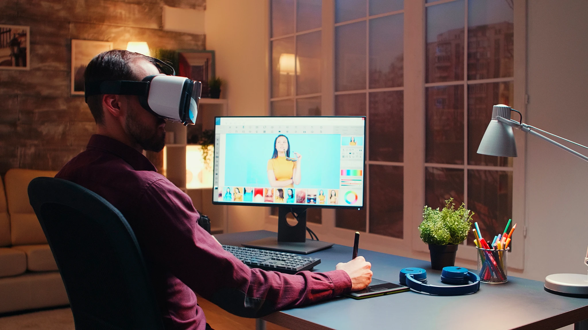 A man sits at a desk wearing a virtual reality headset, immersed in a digital experience.