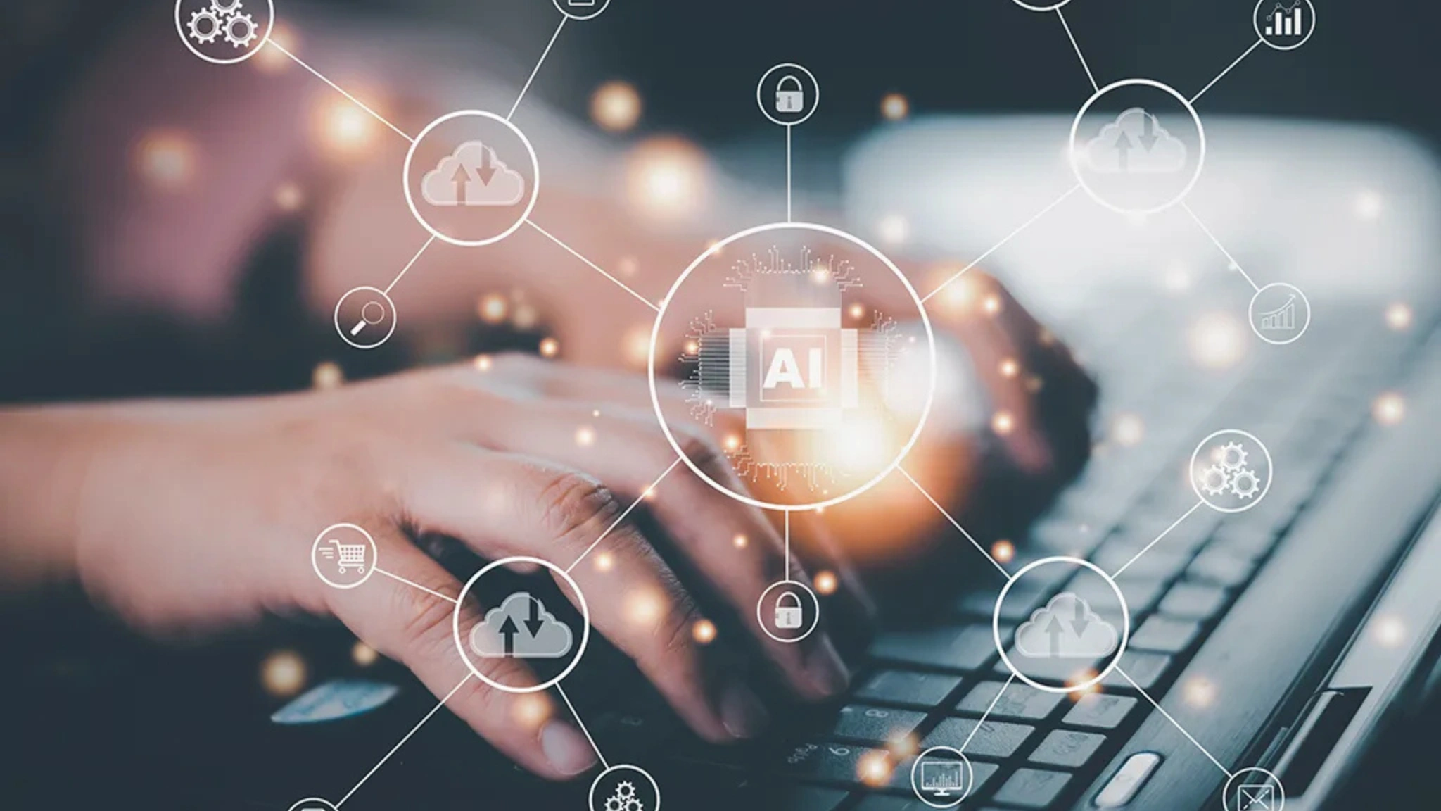 A person focused on a laptop, with various colorful icons displayed on the screen.