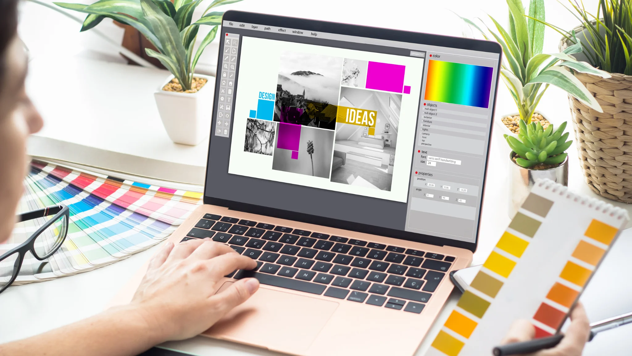 A person is focused on a laptop displaying a vibrant, colorful image on the screen.