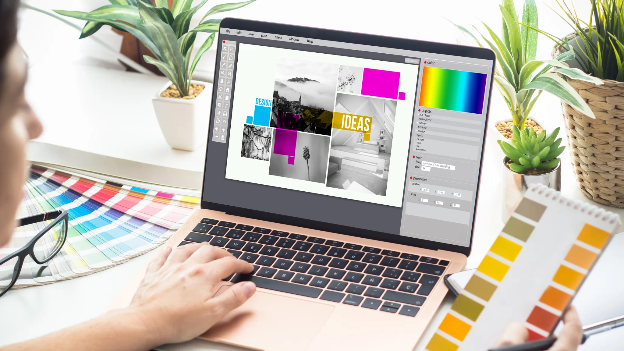 A person focused on a laptop, surrounded by a vibrant graphic design on the screen.