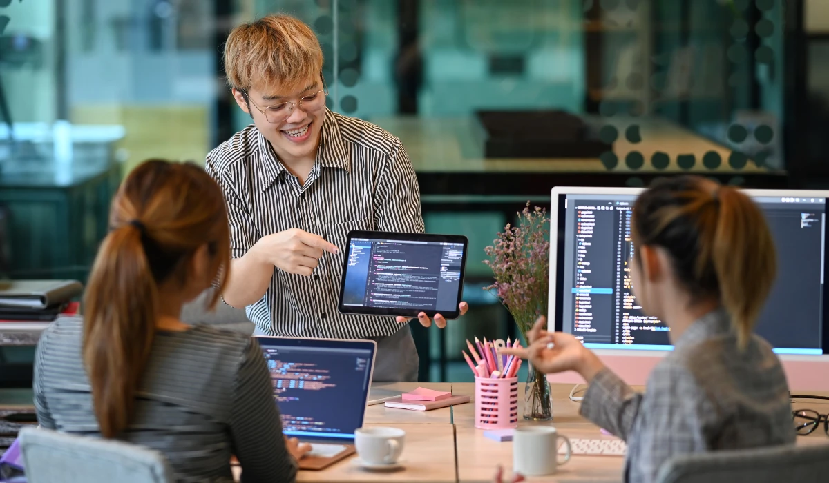 A man and woman are focused on a computer, collaborating and discussing their work together.