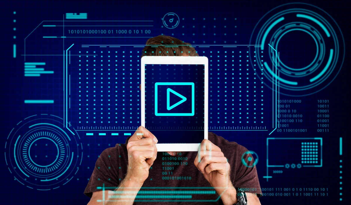 A man is holding a tablet with a visible play button, suggesting he is preparing to play a video or audio clip.