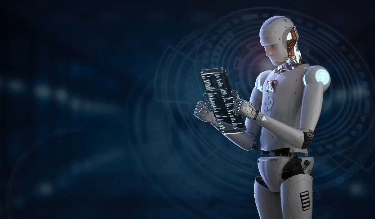 A robot stands in front of a dark background, holding a computer with a focused expression.