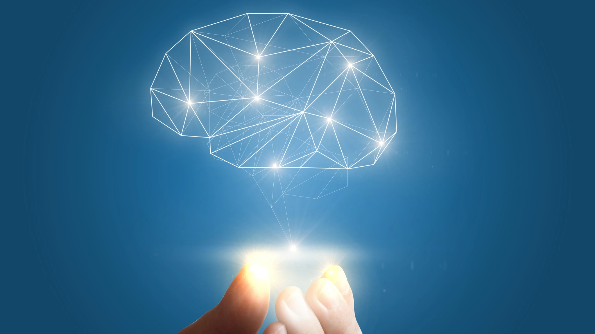 A hand holds a glowing brain, radiating light, symbolizing creativity and intelligence.