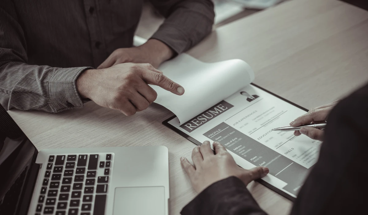 A man at a desk using a computer, with a monitor showing content in front of him.