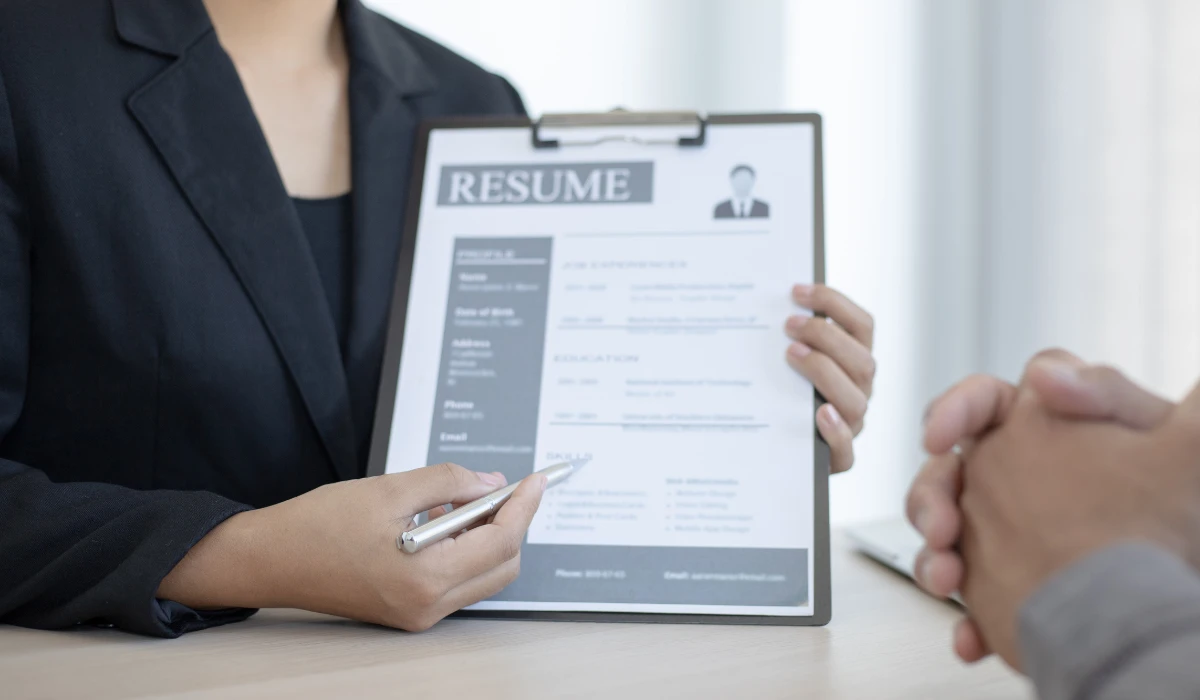 A business-suited individual displays a resume, preparing for a career opportunity or interview.