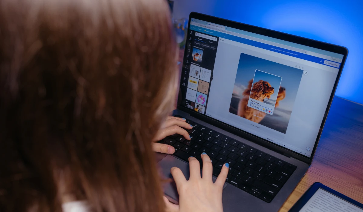 A woman intently typing on her laptop, with a bright and organized desk setting around her.