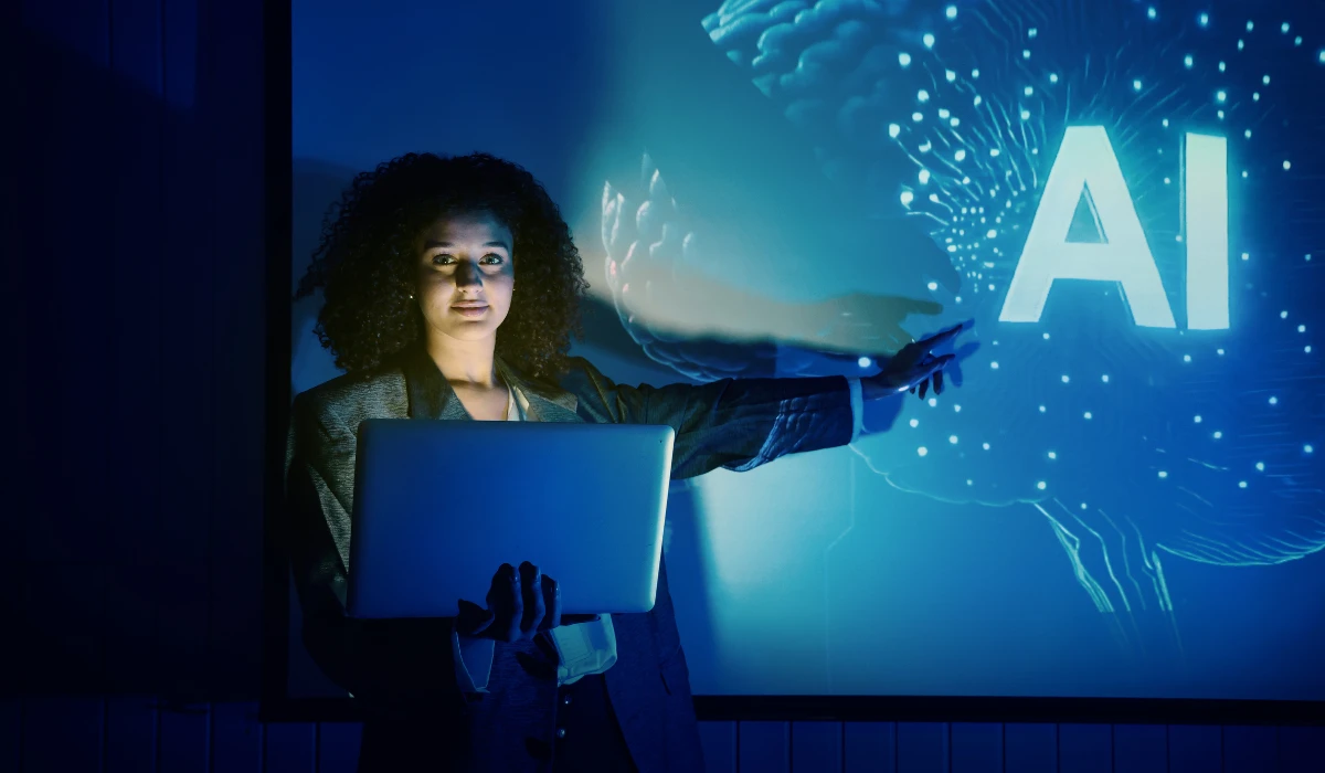A woman demonstrating an AI concept on her laptop, engaged and focused on the screen.