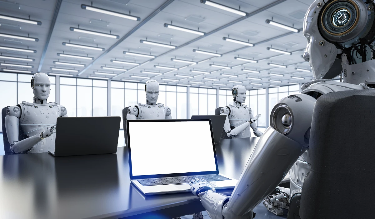 A robot stands in front of a laptop with a blank screen, ready to assist with tasks or programming.