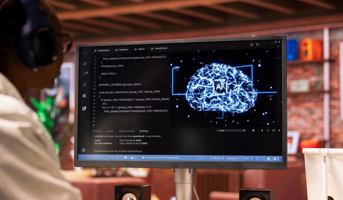 A person wearing headphones looks at a computer screen, engaged in an activity like gaming or video conferencing.